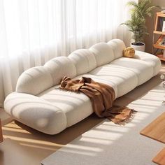 a large white couch sitting in front of a window