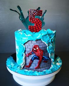 a spiderman cake with blue frosting and icing