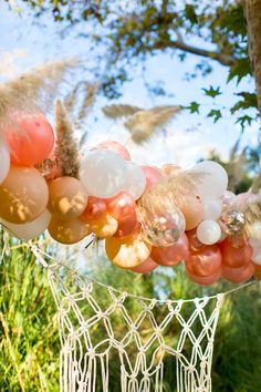 some balloons are hanging in the air near a tree