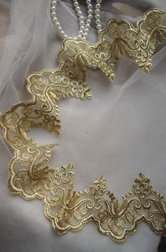 the necklace is adorned with gold filigrees and pearls on a white cloth