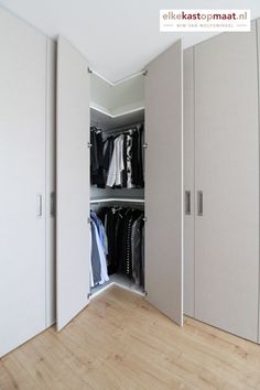 an open closet with clothes on hangers and other items in the closet, as well as two doors