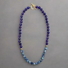 This hand knotted, color blocked necklace exudes the earthy and calming energy of amethyst and kyanite. The knotted blue waxed cord pulls the blue from the kyanite into the purple of the amethyst. The gold plated toggle clasp and accent beads add contrast while the facets of the kyanite and amethyst beads reflect the light giving a high end look. length: 19.5" 8mm faceted amethyst beads 7mm faceted blue kyanite beads polyester waxed cord gold plated accent beads and toggle closure handmade in Li Blue Hand Knotted Jewelry For Gift, Blue Hand-knotted Jewelry For Gift, Artisan Blue Adjustable Crystal Necklaces, Blue Amethyst Hand-strung Jewelry, Blue Amethyst Crystal Necklace For Gift, Blue Hand Knotted Round Bead Necklaces, Blue Hand-knotted Round Bead Necklaces, Blue Hand-knotted Necklaces, Blue Natural Stones Necklace For Everyday Wear