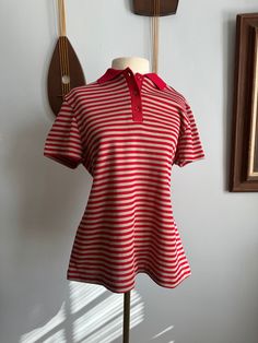 1970s Queen's Casuals Red and Gray Striped Polo Shirt A classic polo shirt made from a durable polyknit. Placket and collar are ribbed, fastening with red buttons. This piece is machine washable and easy to maintain! This fabric has some stretch. Returns are accepted up to 6 days after delivery. Customer is responsible for return postage and a 25% restocking fee. Tracking information must be provided within the 6 days. The refund will be issued upon the items return in its original condition. There are NO exceptions to this policy. By completing this transaction, you are agreeing to this policy. - - Measurements: Bust- 40" Waist- 37" Hip- 40" Sleeve- 7" Shoulder- 16.5" For reference, the dress form typically wears a size S and has a 34" chest. The shirt is marked a women's size L. Striped Polo Shirt, Red Button, Dress Form, Red And Grey, Chicago Il, Grey Stripes, Womens Clothing Tops, 1970s, The Dress