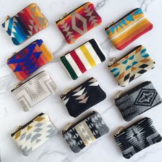 nine different colored clutches sitting on top of a marble counter