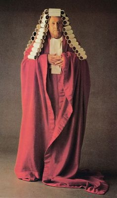 an old man dressed in red and white robes, holding his hands on his chest