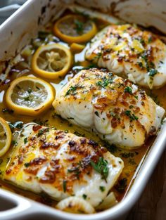 baked fish with lemons and herbs in a casserole dish