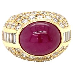 This ravishing 18K yellow gold ring from the 1970s centers a stunning 10-carat oval cabochon ruby, bezel-set and certified by GIA to have no indications of heat treatment, ensuring its natural beauty. The vibrant ruby is enhanced by an array of seventy straight baguette and round brilliant-cut diamonds totaling 3.45 carats, with G-H color and VS-2 clarity, adding a sleek and radiant sparkle. Measuring 16 mm wide and sitting 12 mm high on the finger when worn, this ring commands attention with it Cabochon Ruby, 18k Yellow Gold Ring, Domed Ring, Ruby Diamond, Fine Jewelry Collection, Yellow Gold Ring, Belleza Natural, Oval Cabochon, Round Brilliant Cut Diamond