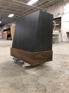 a large black box sitting on top of a dolly in a warehouse floor next to other boxes