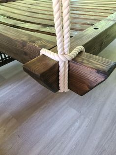 a wooden bed frame with ropes attached to it