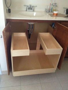 an open cabinet in the middle of a bathroom with two sinks and one countertop