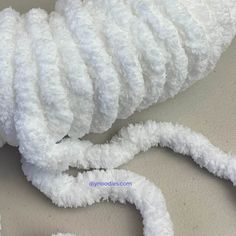 there is a white rope that has been wrapped in some kind of yarn on the table