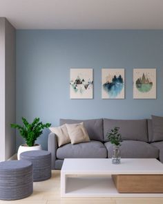 a living room filled with furniture and paintings on the wall above it's coffee table