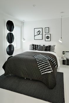 a bedroom with black and white decor on the walls, bedding, and rugs