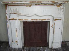 an old white fireplace with peeling paint on it