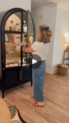 a woman standing in front of a glass case