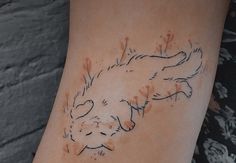 a woman's arm with an inked cat on the left side of her body