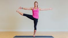 a woman in a pink tank top and black leggings doing a yoga pose