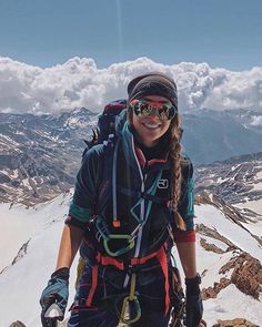 a woman hiking up the side of a snow covered mountain