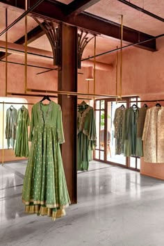 the inside of a clothing store with mannequins and dresses hanging on racks