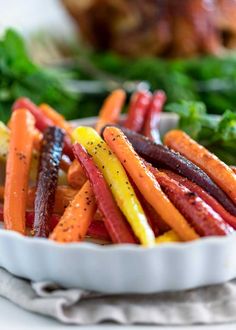 carrots and other vegetables are in a white bowl