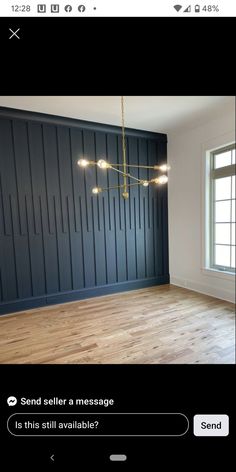 an empty room with dark blue walls and wood floors