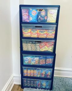 a blue shelf filled with food on top of carpeted floor next to white wall