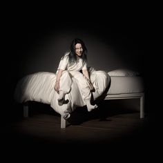 a person sitting on a bed in the dark