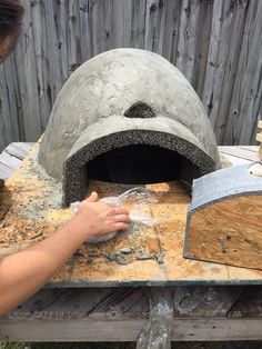 a man is working on an outdoor pizza oven