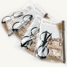 five pairs of reading glasses sitting on top of each other in plastic bags with the words made god written on them