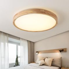 a bedroom with a large bed and wooden headboard on the wall next to windows