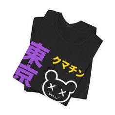 Description Show off your enby pride with this adorable Tokyo Kumachin Nonbinary Shirt. Made from high-quality materials and featuring the iconic nonbinary flag colors, this cute and kawaii nonbinary shirt is the perfect way to celebrate your identity. Shirt Details • Gender Neutral• 100% Cotton• Light fabric• Retail fit• Tear away label• Runs true to size Trendy Character Print Shirt For Streetwear, Trendy Black Shirt With Character Print, Purple Cartoon Print Top For Streetwear, Purple Character Print Top For Streetwear, Harajuku Style Black Shirt With Anime Print, Enby Shirts, Kawaii Graphic Tops For Streetwear, Kawaii Black Top For Streetwear, Harajuku Style Black Anime Print Shirt