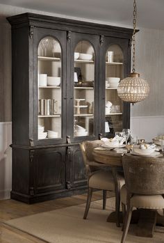 a dining room table with chairs and china cabinet