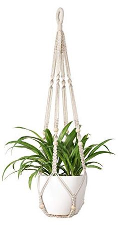 a white hanging planter with green plants in it