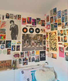 a bedroom with posters on the wall and pictures on the wall above it, along with a bed