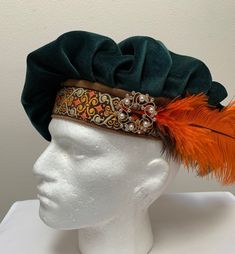 "A new professional quality Renaissance Medieval Tudor Scottish Irish muffin floppy hat. This green flocking velvet floppy hat is embellished with a brocade band and brown and orange feathers. Side medallion will vary in design. Fully lined. New not worn. A great accent for your Medieval Renaissance outfit for your reenactment event, theme party or stage production. Sales final. Will exchange for a different size. Size small has a 22\" band Size medium has a 22 1/2\" band Size large has a 23\" b Adjustable Green Costume Hats And Headpieces, Tybalt Capulet, Peasant Core, Medieval Hats, Tudor Period, Celtic Green, French Hat, Stage Production, Medieval Party