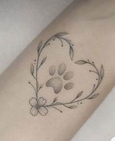 a dog paw and flower tattoo on the right arm, with an arrow in the center