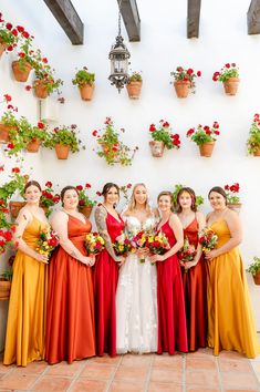 a group of women standing next to each other in front of flower potted plants