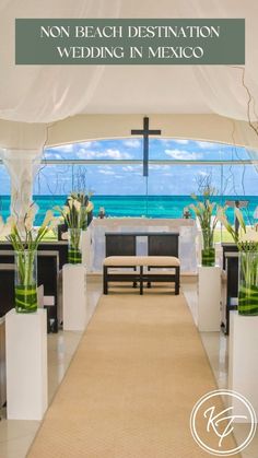 an outdoor wedding venue with white flowers and greenery on the aisle, overlooking the ocean