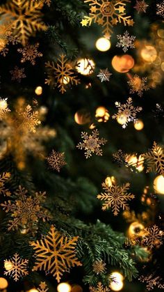 a christmas tree with gold and white snowflakes hanging from it's branches