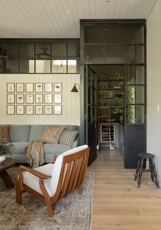 a living room filled with furniture and pictures on the wall next to a doorway that leads to another room