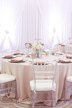 the table is set with white linens and gold plates