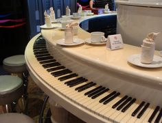 the piano is decorated with coffee cups and saucers