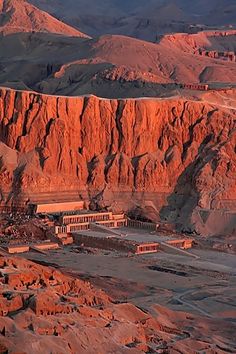 an aerial view of the desert with mountains in the back ground and buildings on either side