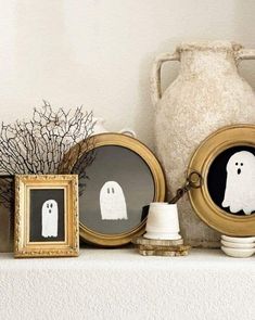 there are three pictures on the mantle with ghost decorations in front of them, and one is framed