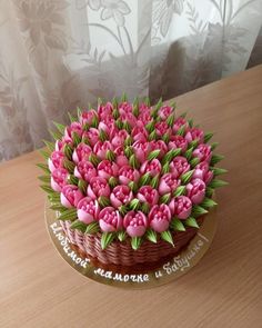 a cake decorated with pink flowers on top of a wooden table