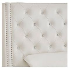 an upholstered white headboard with studding and buttons on the back side