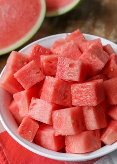 a white bowl filled with watermelon slices on top of a table