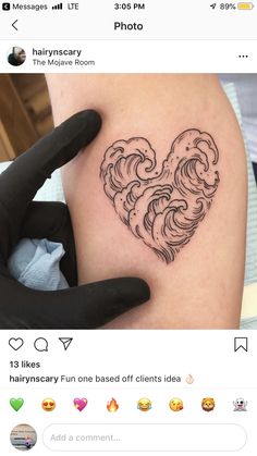 a heart shaped tattoo on the back of a woman's arm