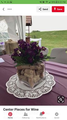 there is a vase with flowers and wine corks in it on top of a table