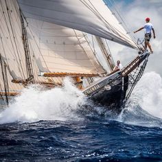 a man is on top of a sailboat in the ocean